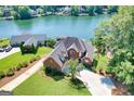 Stunning aerial view of brick home on waterfront with a lush lawn, mature trees, and expansive lake view at 1283 Heritage Dr, Villa Rica, GA 30180