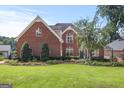 Charming brick home with manicured lawn, mature trees, and traditional design; perfect for comfortable living at 1283 Heritage Dr, Villa Rica, GA 30180