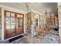 Charming stone porch with wooden rocking chairs and double doors at 210 Steeple Point Dr, Roswell, GA 30076