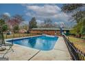 Backyard featuring a refreshing in-ground pool surrounded by an iron fence at 10174 Twin Oaks Sw Dr, Covington, GA 30014