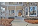 Charming front entrance featuring a beautiful wood door, stone accents and a welcoming porch at 215 Farr Lake Dr, Tyrone, GA 30290