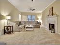 Bright living room with a large sectional sofa, fireplace, and neutral color palette at 215 Farr Lake Dr, Tyrone, GA 30290