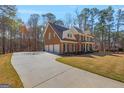 Spacious brick home with three-car garage, long driveway and landscaped front yard at 125 Tall Timber Ct, Fayetteville, GA 30215
