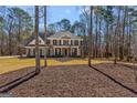 Two-story brick home with mature trees, lush lawn, and classic architectural details at 125 Tall Timber Ct, Fayetteville, GA 30215
