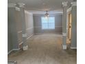 Spacious living room featuring decorative columns, neutral carpet, and ample natural light at 11 Carriage Lake Dr, Stockbridge, GA 30281