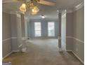 Bright living room with decorative columns, neutral carpet, and multiple windows at 11 Carriage Lake Dr, Stockbridge, GA 30281