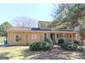 Classic home boasts a welcoming front porch, manicured bushes, and a well-kept lawn on a sunny day at 401 Waterwood Bnd, Peachtree City, GA 30269