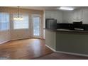 Bright kitchen with white cabinets, black countertops, black appliances, and hardwood-floored dining area at 1694 Social Circle Fairplay Rd, Social Circle, GA 30025