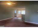 Cozy living room featuring brown carpet, ceiling fan, and an opening to another room at 1694 Social Circle Fairplay Rd, Social Circle, GA 30025