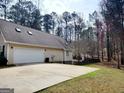 Two-car garage with a spacious driveway and a cozy backyard at 3213 Sweetbriar Dr, Villa Rica, GA 30180