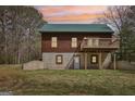 Charming log cabin featuring a second-story balcony and walkout basement with a well-maintained lawn at 1266 Martin Mill Rd, Moreland, GA 30259
