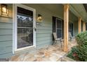 Inviting front porch with stone flooring, decorative wood columns and sconce lighting at 2431 Weatherford Ct, Marietta, GA 30068