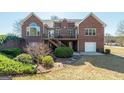 Brick home featuring a wooden deck, walkout basement and well-maintained landscaping at 408 Tomahawk Trl, Mcdonough, GA 30252