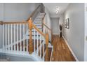 Bright hallway with stairs, hardwood floors, neutral walls, and modern track lighting, creating a welcoming entrance at 1383 Dolcetto Nw Trce # 9, Kennesaw, GA 30152