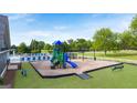 Community playground featuring a slide and climbing structures, surrounded by artificial turf at 1716 Goodwin Dr, Hampton, GA 30228
