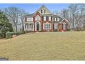 Beautiful brick home with a well-kept lawn, mature trees, and classic architectural details at 1133 Astoria Ln, Peachtree City, GA 30269
