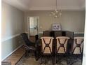 Formal dining room showcasing an elegant chandelier, a decorative rug, and seating for six around a wooden table at 135 Lucky Leaf Pl, Fayetteville, GA 30214