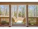 View from the charming covered front porch overlooking a serene wooded area at 150 Gill Ln, Stockbridge, GA 30281