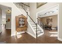 Elegant entryway boasts hardwood floors, grand staircase, and an antique display cabinet at 2715 Ivey Crossing Trl, Cumming, GA 30041