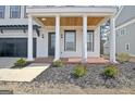 Inviting front porch with white columns, a stained wood ceiling, and well-manicured landscaping at 446 Bandon Way, Peachtree City, GA 30269