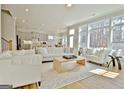 Bright living room with large windows, hardwood floors, and modern, comfortable white furniture at 446 Bandon Way, Peachtree City, GA 30269