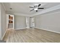 Spacious living room with light wood floors, ceiling fan, and access to other rooms at 401 Pinegate Rd, Peachtree City, GA 30269