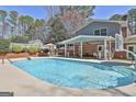 Relaxing backyard featuring a refreshing in-ground pool, covered patio, and basketball court at 401 Pinegate Rd, Peachtree City, GA 30269