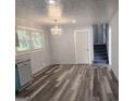 Bright dining area featuring updated flooring, stairs to the upper level and a modern chandelier at 938 King James Dr, Morrow, GA 30260