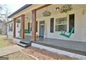 Inviting front porch with swing chairs and decorative hanging plants, creating a cozy and welcoming entrance at 1120 Minix Rd, Sharpsburg, GA 30277