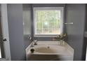 Bright bathroom featuring a large soaking tub by a window at 332 Black Willow Ct, Locust Grove, GA 30248