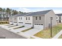 Rear view of newly constructed townhomes, each with private garages and modern siding at 460 Reflection Dr # 21, Stockbridge, GA 30281