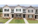 New townhome exteriors featuring brick and stone accents, black shutters, and professionally landscaped front yards at 460 Reflection Dr # 21, Stockbridge, GA 30281