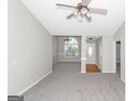 Bright living room with carpet, neutral walls, ceiling fan, and large windows offering ample natural light at 75 Heatherstone Way, Covington, GA 30016