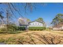Spacious two-story home with a well-manicured lawn and mature trees, creating a serene setting at 3006 Deshong Dr, Stone Mountain, GA 30087