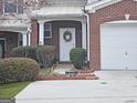 Close-up of the front door with a decorative wreath and landscaped garden bed at 102 Ellis Dr, Conyers, GA 30012