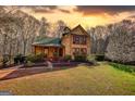 Warm sunset lights up a charming two-story home and its well-manicured lawn at 5642 N Highway 212, Covington, GA 30016