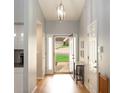 Bright foyer with hardwood floors and elegant lighting fixture at 1067 Pinehurst Dr, Peachtree City, GA 30269