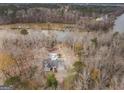 Aerial view of a home nestled in a dense forest near a tranquil river or lake, offering a serene natural setting at 650 Malcom Rd, Covington, GA 30014