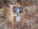 Aerial view showcases a home and a unique outdoor feature, possibly a pool or deck, set amidst a wooded landscape at 650 Malcom Rd, Covington, GA 30014