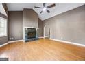 Spacious living room with a stone fireplace, high ceilings, and light wood flooring at 1620 Summit Rdg, Auburn, GA 30011