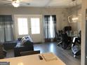 Bright living room with modern furniture, glass table, and french doors to outside at 1848 Eastmore Ave, Conyers, GA 30094