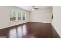 Spacious living room with dark hardwood floors, large windows, and a ceiling fan at 903 Hollytree Pl, Acworth, GA 30102