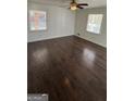 Spacious bedroom featuring hardwood floors, a ceiling fan, and natural light at 220 Cabriolet Trl, Mcdonough, GA 30253