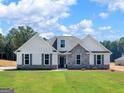 Beautiful single-Gathering home exterior with stone accents, gray shutters, well-maintained lawn and landscaping at 4139 Alayna Lee Cir, Mcdonough, GA 30252