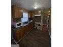 Traditional kitchen with wood cabinets, stainless sink, and tiled backsplash at 452 Fedora Nw Way, Atlanta, GA 30331