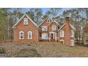 Inviting red brick home featuring a classic architectural design with white trim, arched windows, and a covered entryway at 165 Standing Oak Pl, Fayetteville, GA 30214