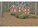 Beautiful two-story brick house with well-maintained landscaping surrounded by trees and a green lawn at 165 Standing Oak Pl, Fayetteville, GA 30214