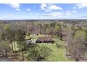 Aerial view of a brick home with lush surroundings and a detached garage at 7395 Old Rico Rd., Chattahoochee Hills, GA 30268