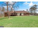 Expansive backyard featuring a well-maintained lawn and a wooden deck at 7395 Old Rico Rd., Chattahoochee Hills, GA 30268