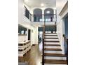 Bright foyer featuring hardwood floors, a staircase with iron railings, and an upper level balcony at 1521 Ashbury Park Dr, Hoschton, GA 30548
